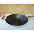 Large vintage steel wok with wooden handle. This is a very large and heavy duty wok.