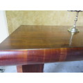 An exceptional Art Deco walnut dining table. The figured walnut book matched veneered shaped top