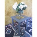 A stunning square chalk painted side table with a glass top