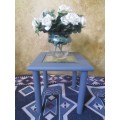 A stunning square chalk painted side table with a glass top