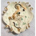 A charming wall hanging plaque featuring the portrait of a woman. It has been cast from porcelain