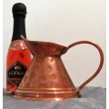 This is a beautiful, shiny copper jug. The jug has a lovely large curved handle