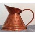 This is a beautiful, shiny copper jug. The jug has a lovely large curved handle