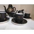 Japanese porcelain coffee set, the mat black body with gilt highlights