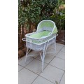 Lovely white cane bassinet on a stand.