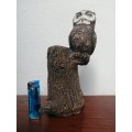 Beautiful, heavy sculptured owl on a tree trunk.