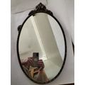 Vintage Gold Oval Mirror With Ornate Detail on top of The Mirror.