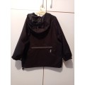 Black Woolworths rain jacket 5-6 with reflector strips and large zipped pocket at back