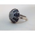 A STUNNING ROUND SILVER RING SET WITH AN ASSORTMENT OF BLACK AND CLEAR CRYSTAL STONES SIZE N