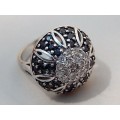 A STUNNING ROUND SILVER RING SET WITH AN ASSORTMENT OF BLACK AND CLEAR CRYSTAL STONES SIZE N