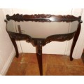 Ornately carved occasional half-moon table with Louis XV  legs and glass top
