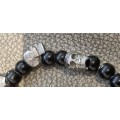 Black onyx stone bead stretch bracelet with 3 skull charms