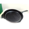 A vintage large pre seasoned with grid heavy cast iron cooking skillet pan with flu.