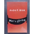 Met `n glimlag / Andre P. Brink