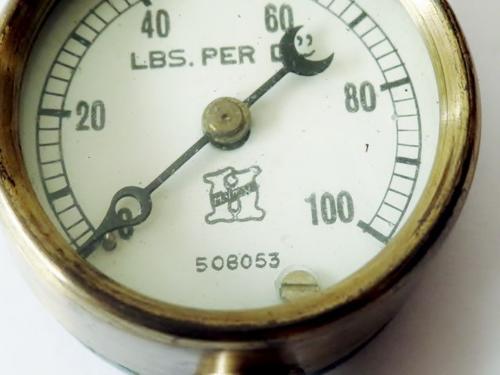 Small antique cast iron pressure gauge with brass plated trim in original case with 3 needles